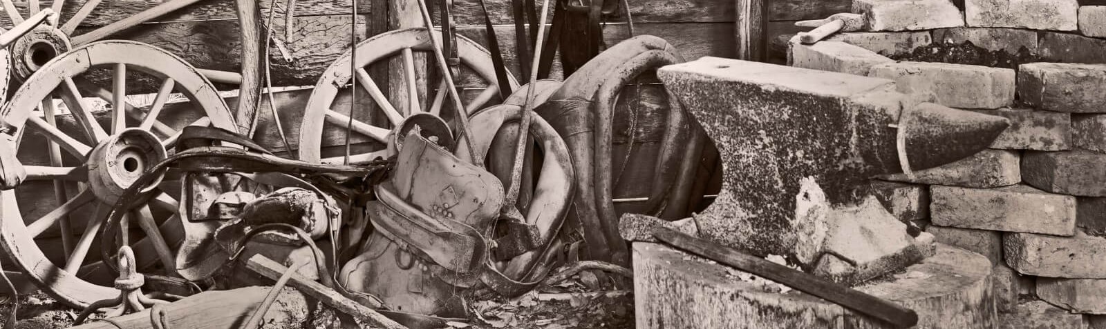 Un photo de divers outils et équipements de forge sur le plancher d’une forge.